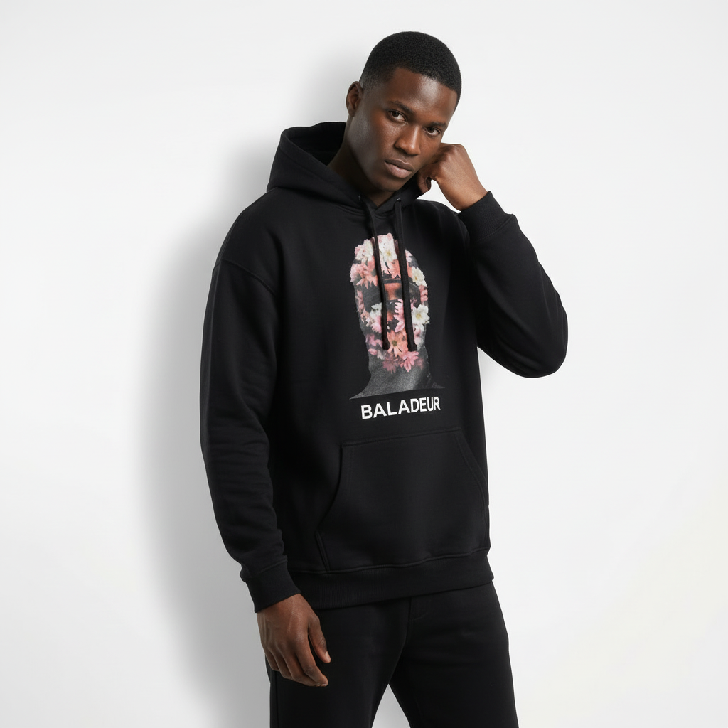 Person wearing a black hoodie with floral design and 'Baladeur' text on a white background
