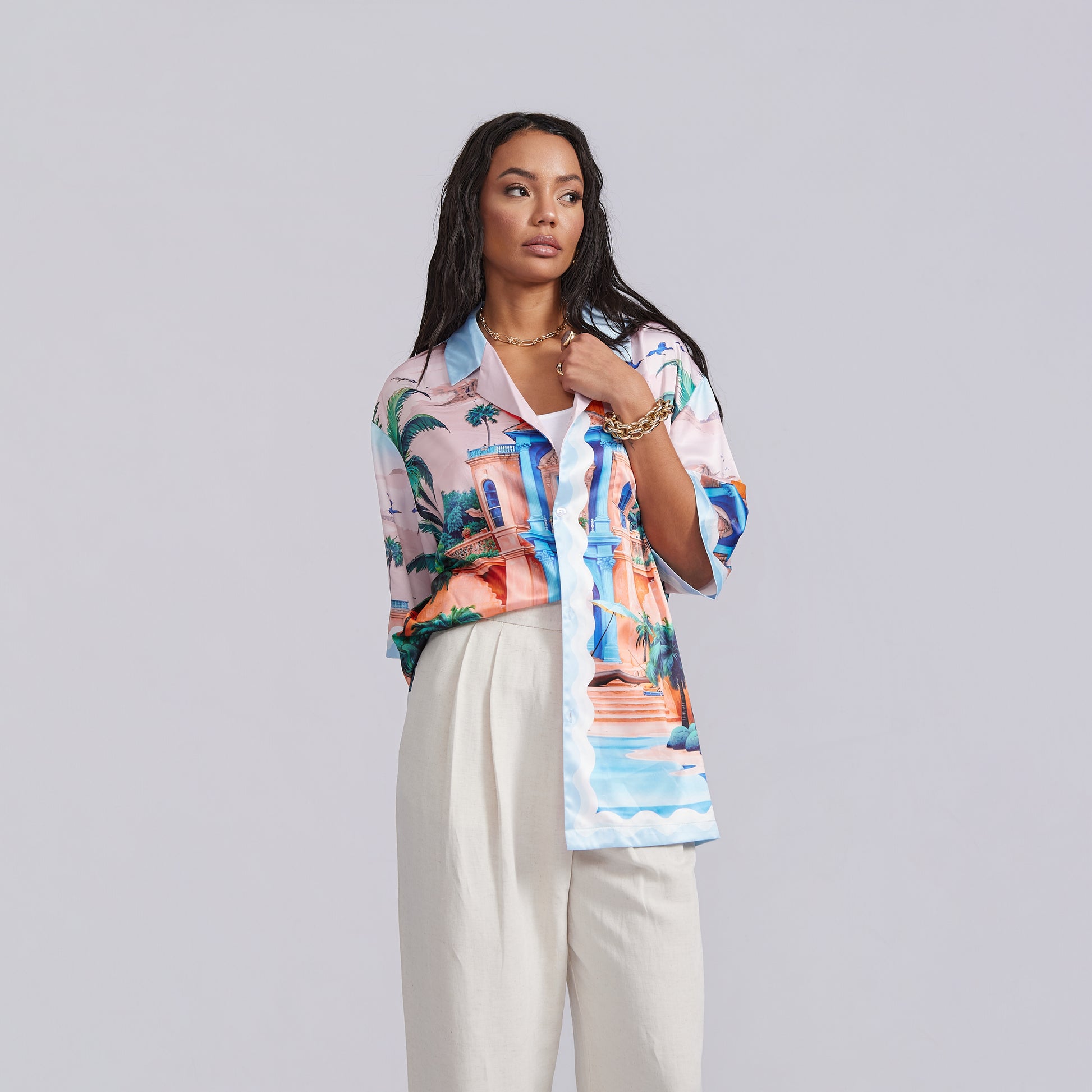 Woman wearing a colorful patterned shirt with a plain background